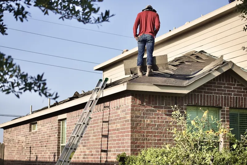 Professional roofer working on a residential roof in Hudson Center